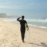 man in black jacket walking on beach during daytime