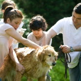 woman in white shirt holding brown short coated dog